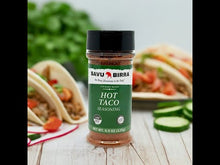 Savu Birra Hot Taco Seasoning Blend bottle in front of delicious tacos with fresh ingredients.